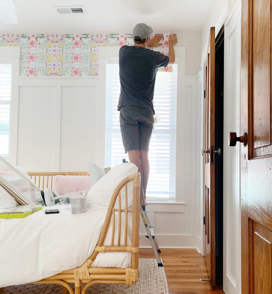 John Sticking Sheet Of Peel And Stick Wallpaper Above Window