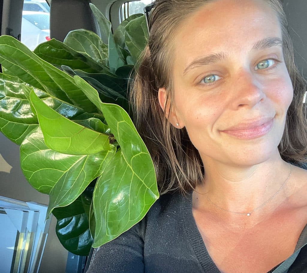 Sherry sitting with fiddle leaf fig in car