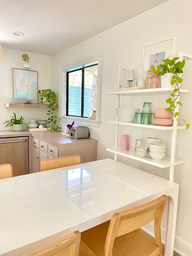 White CB2 Breakfast Table Against White Wall Shelf With Bowls And Cups