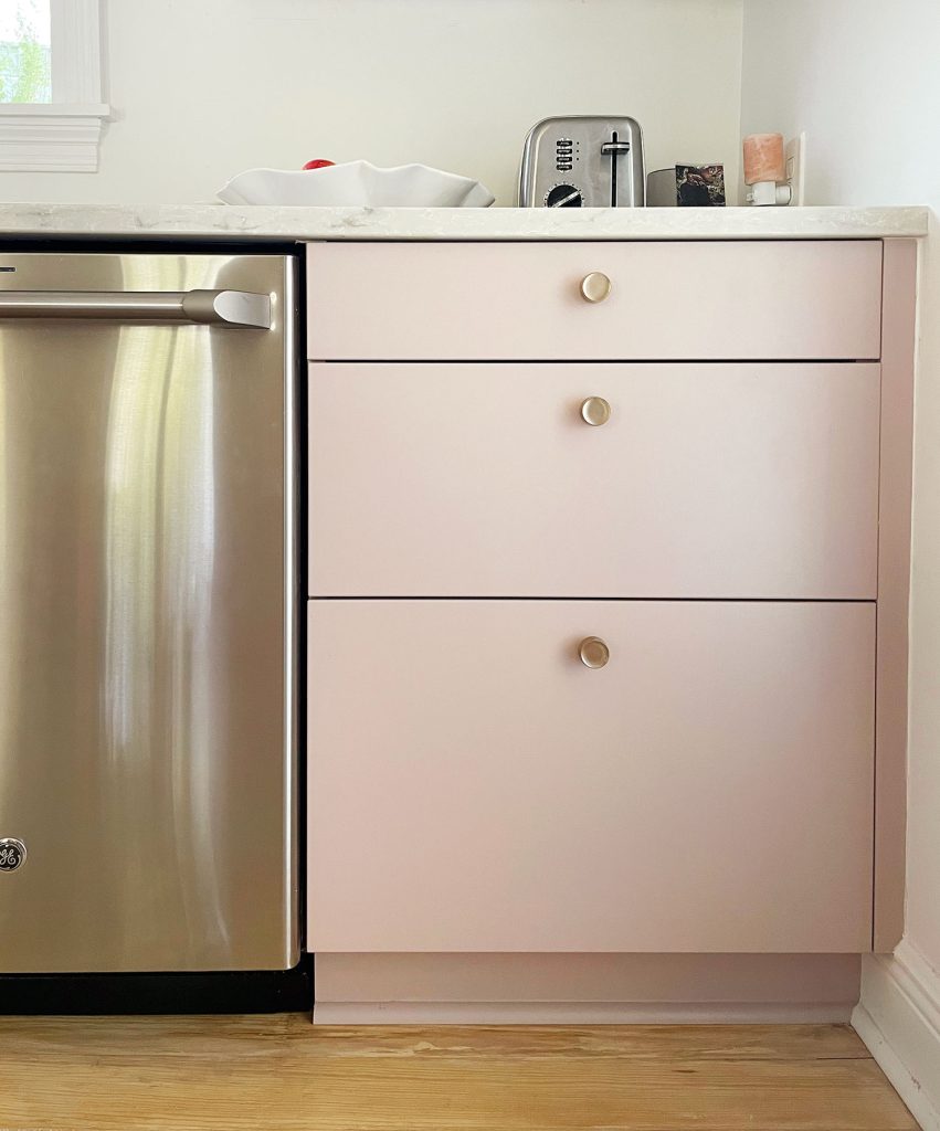 Completed Ikea kitchen with painted drawer fronts and brass knobs