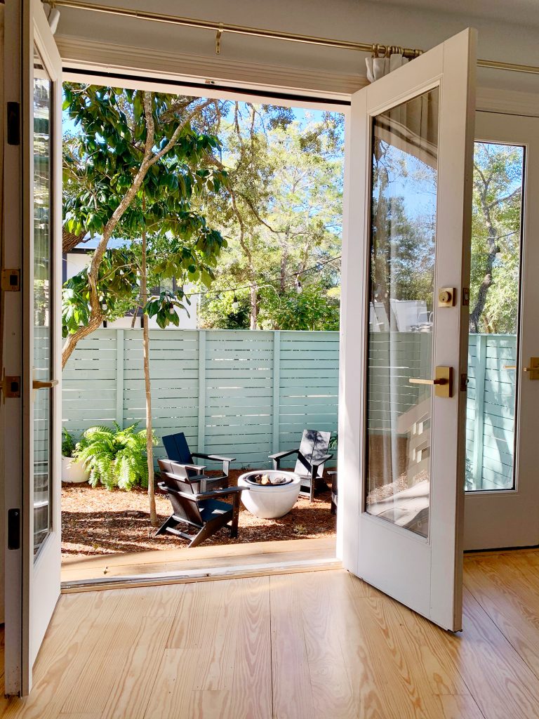 View of fire pit area through open french doors in bedroom