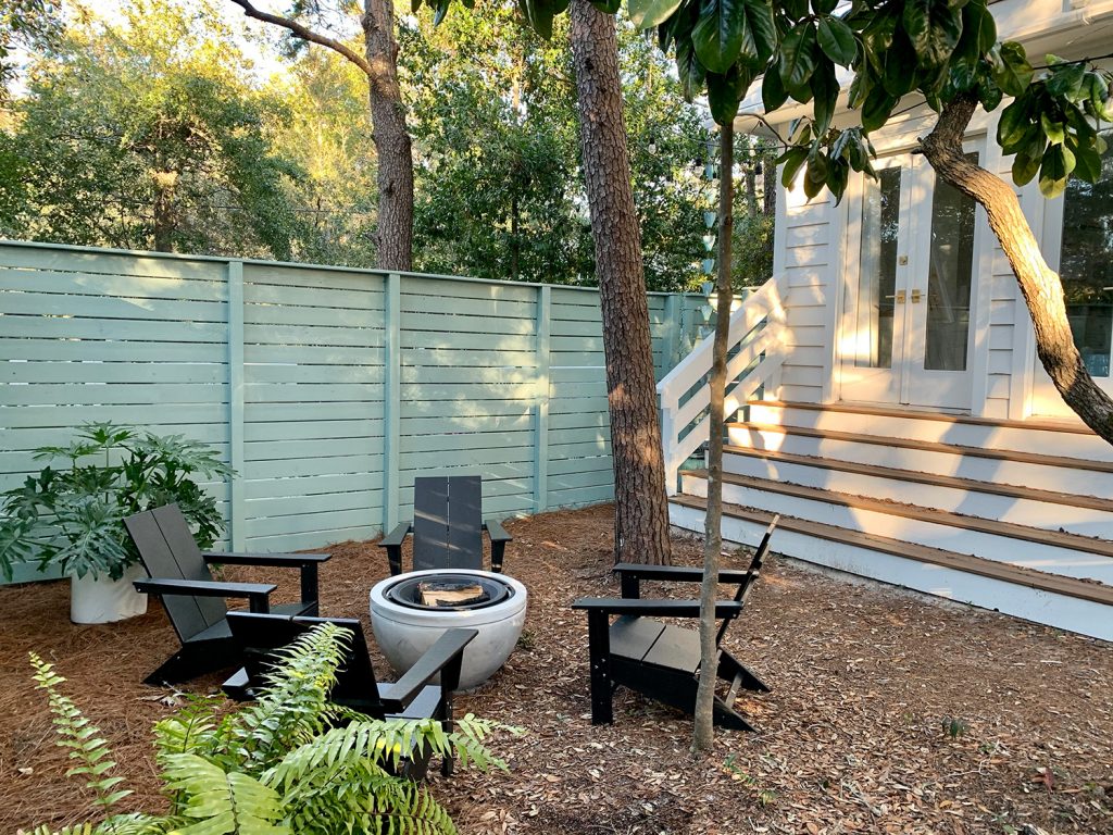 Blue-green painted horizontal fence around side yard with long steps leading up to bedroom