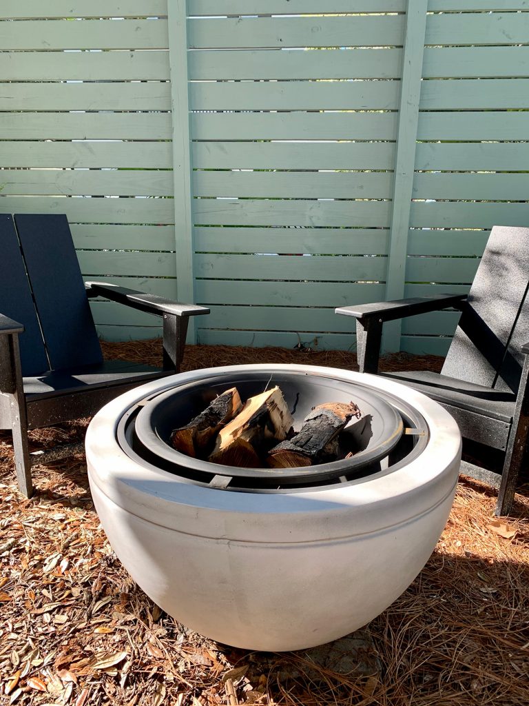 Detail of faux stone fire pit with burnt logs in it