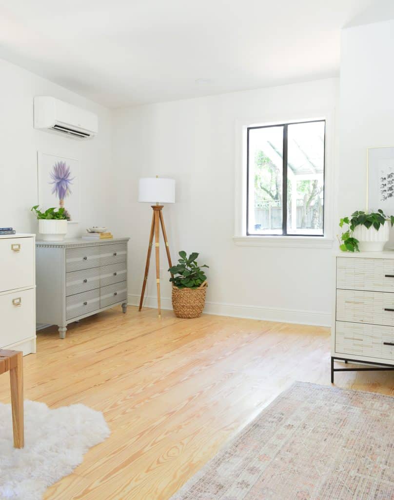 Before photo of corner of bedroom after moving in with random dressers and lamps